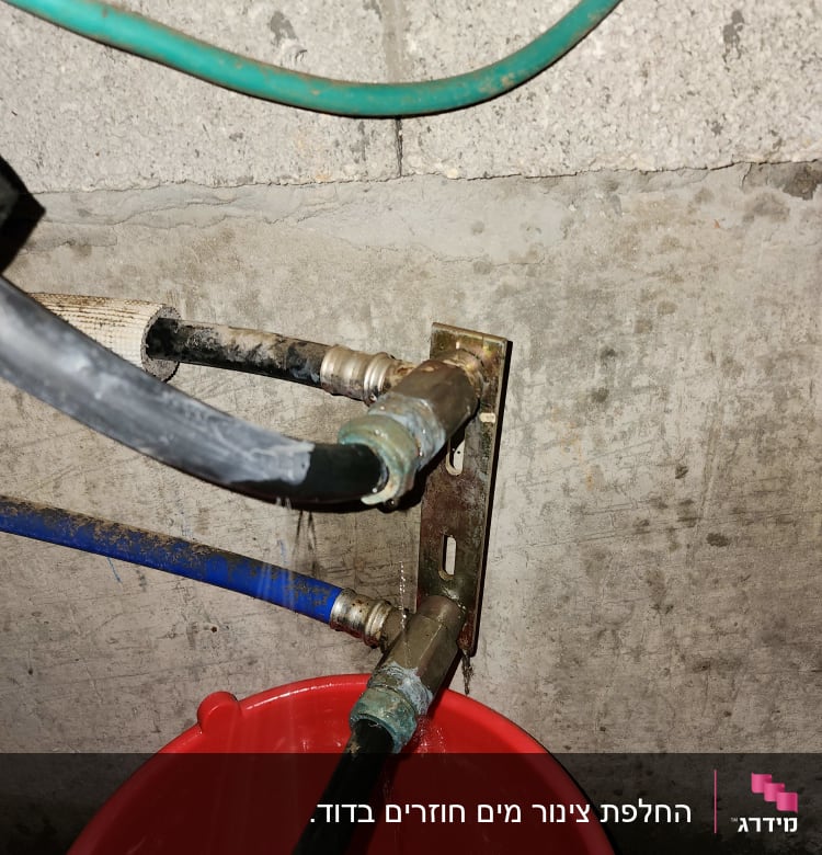 דליפת מים מצינור לתוך דלי אדום